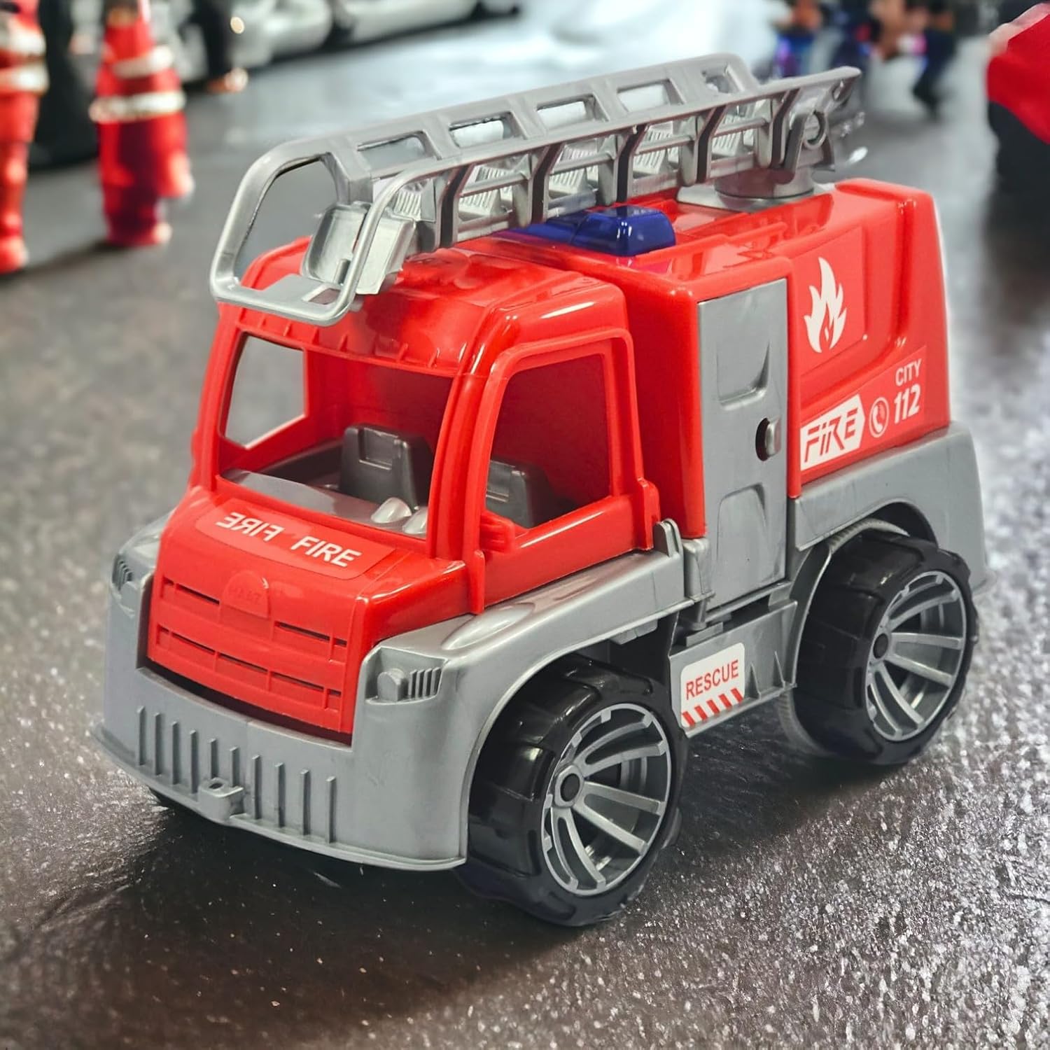 Toy fire truck with ladder on a reflective surface