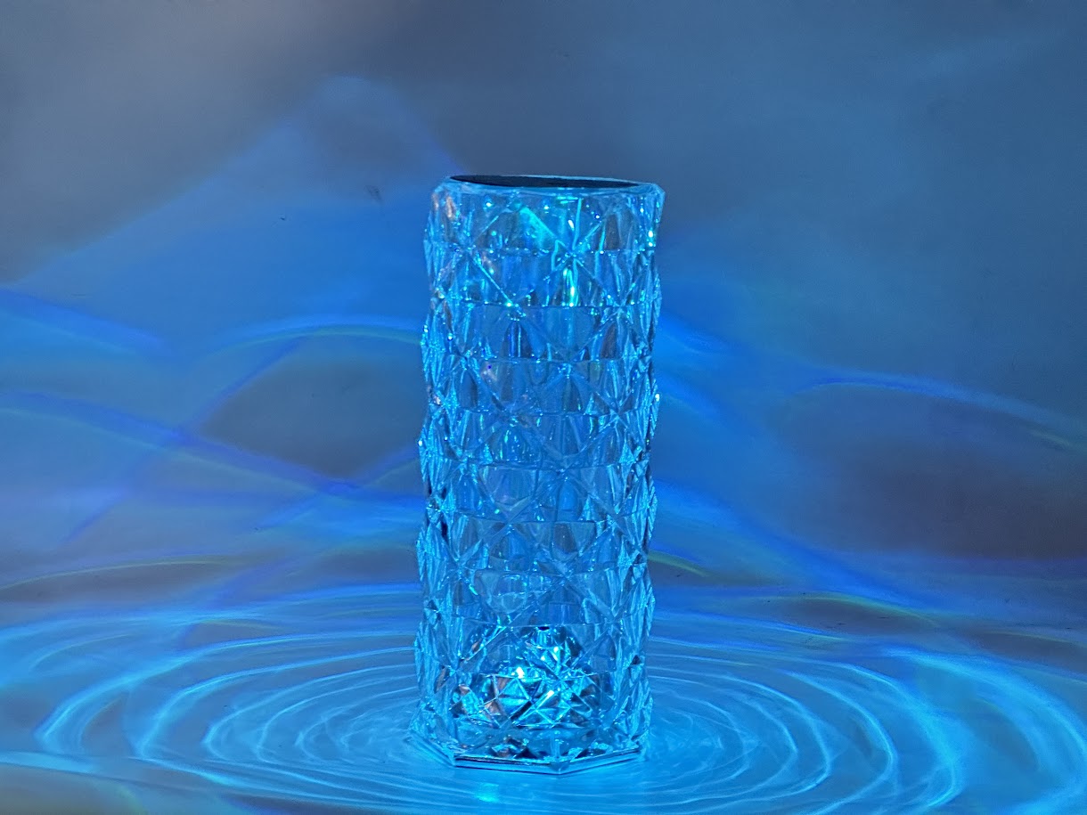 Crystal vase with blue lighting on a reflective surface