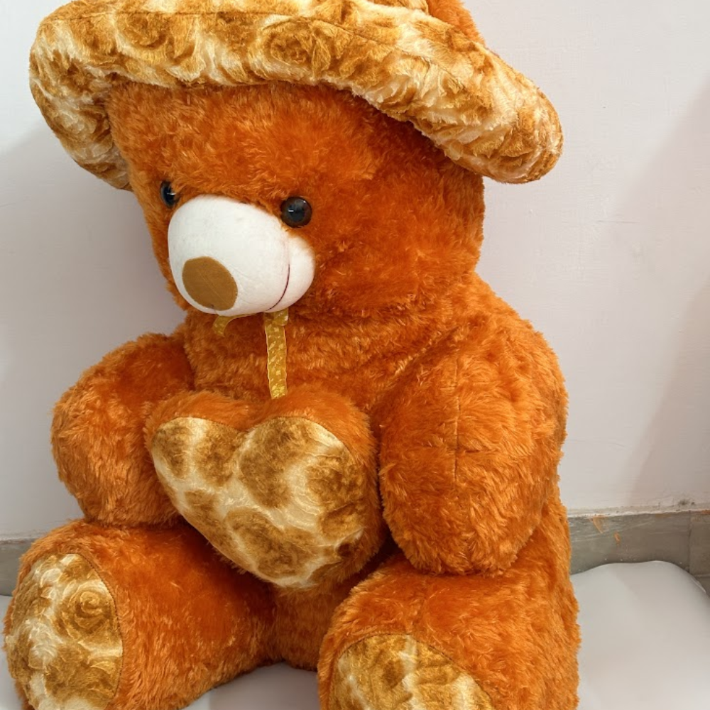 Brown teddy bear with a heart-shaped patch on a white background