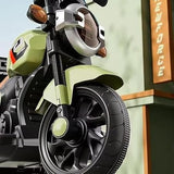 Close-up of a toy motorcycle with a green seat and black wheels, set against a blurred background.