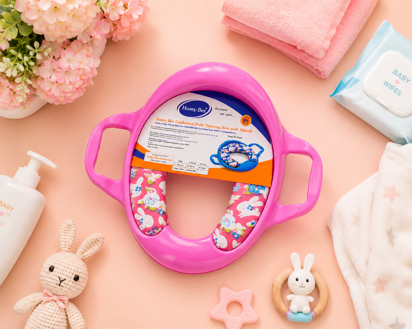 Top view flat lay of Honey Bee cushioned potty training seat with baby care accessories