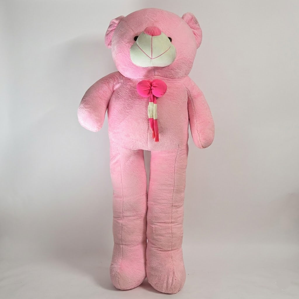 Large pink teddy bear with a bow tie on a light gray background