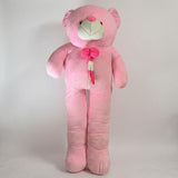 Large pink teddy bear with a bow tie on a light gray background