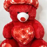 Red teddy bear with a heart-shaped chest on a white background