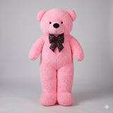 Pink teddy bear with a bow tie on a gray background